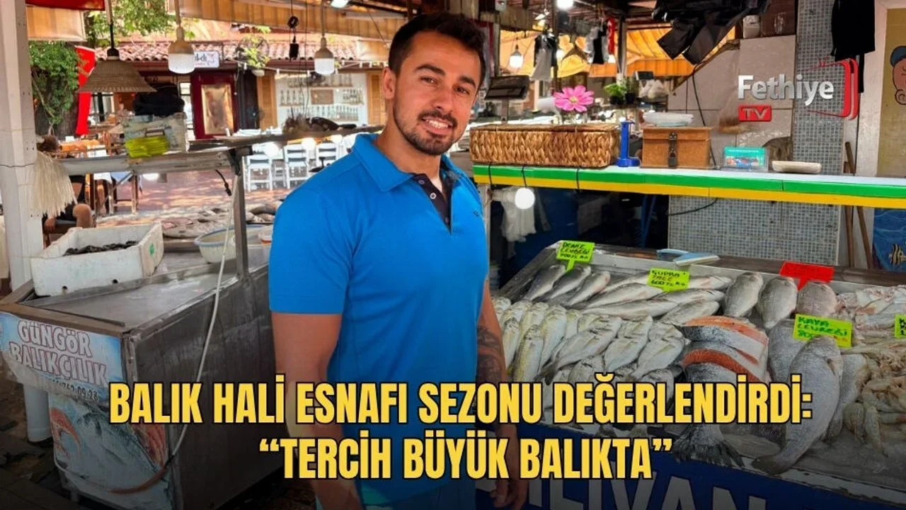 Balık pazarı esnafı Talip Munis tezgahındaki taze deniz ürünlerini müşterilere tanıtıyor.