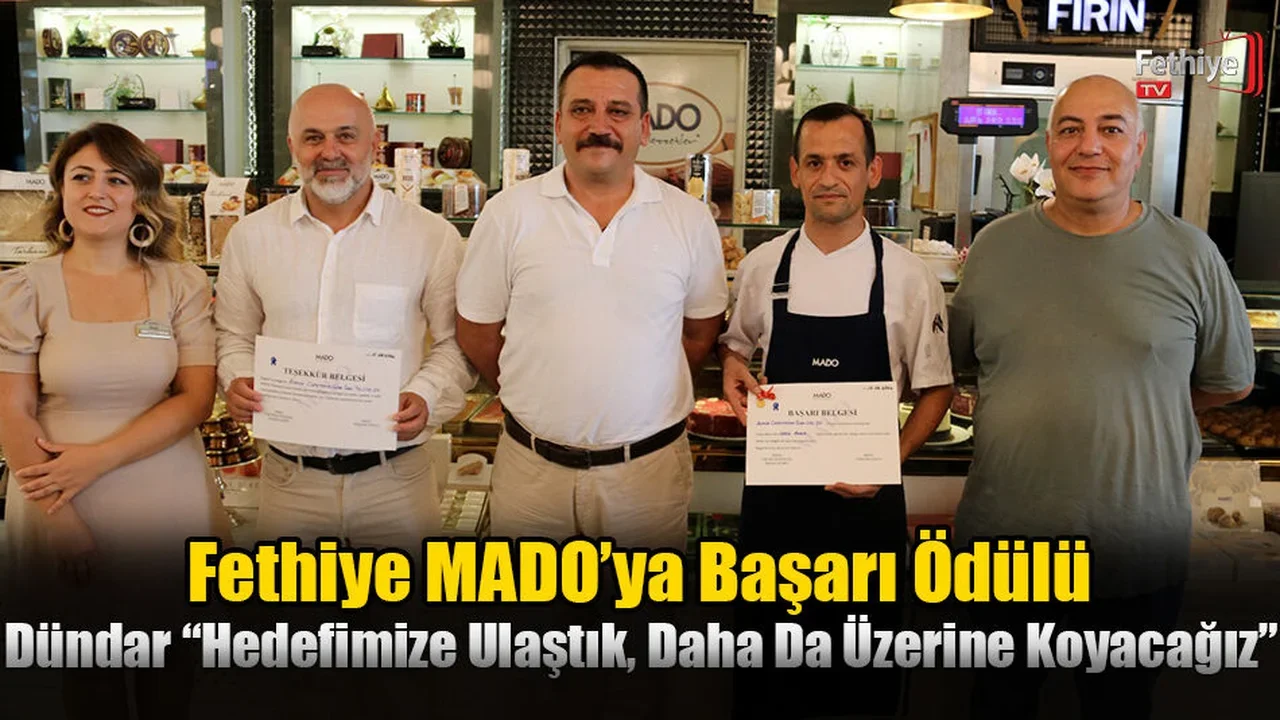 MADO Fethiye Şubesi'nde ödül töreninde işletmeci Salih Dündar ve bölge müdürü belgeleri takdim ediyor.