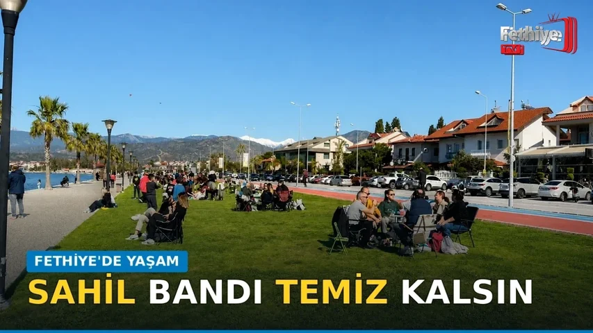 Fethiye 3. Etap Sahil Bandı'nda vatandaşlar gün batımını izleyerek çimlerde dinleniyor.