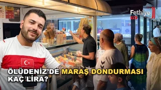 Ölüdeniz'de dondurma işletmesinde Maraş dondurması satan esnaf, fiyat listesini göstererek açıklama yapıyor.