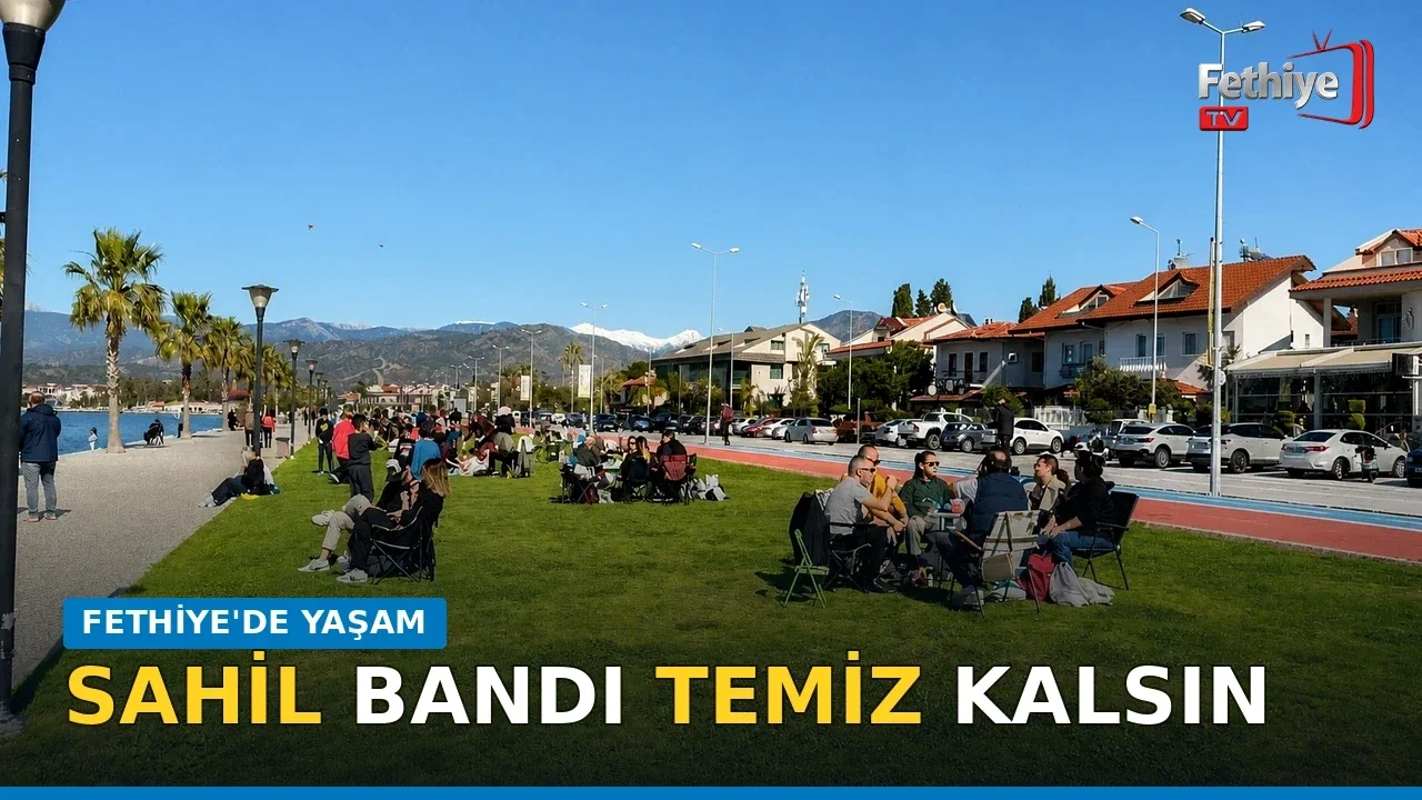 Fethiye 3. Etap Sahil Bandı'nda vatandaşlar gün batımını izleyerek çimlerde dinleniyor.