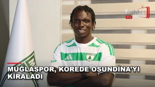 Korede Osundina, Muğlaspor Futbol Şube Sorumlusu Abdullah Eskihisarlı ile birlikte imza töreninde poz veriyor.