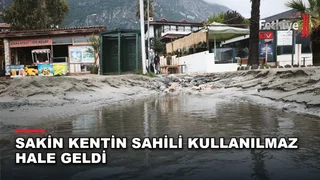Dalaman Akkaya Mahallesi sahilinde şiddetli yağmur sularının kumları denize sürüklediği hasar görülüyor.