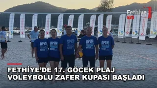 Göcek'te düzenlenen plaj voleybolu turnuvasında bir grup sporcu kumda mücadele ediyor.