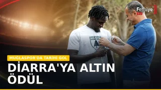 Muğlaspor Kulübü Başkanı Menaf Kıyanç, antrenman sonrası futbolcu Mamady Diarra'yı altınla ödüllendiriyor.