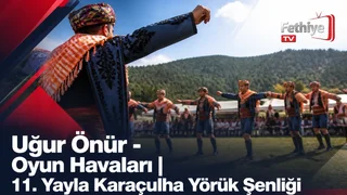Uğur Önür sahnede şarkı söylerken seyirciler coşkuyla eşlik ediyor, şenlik alanı kalabalık.