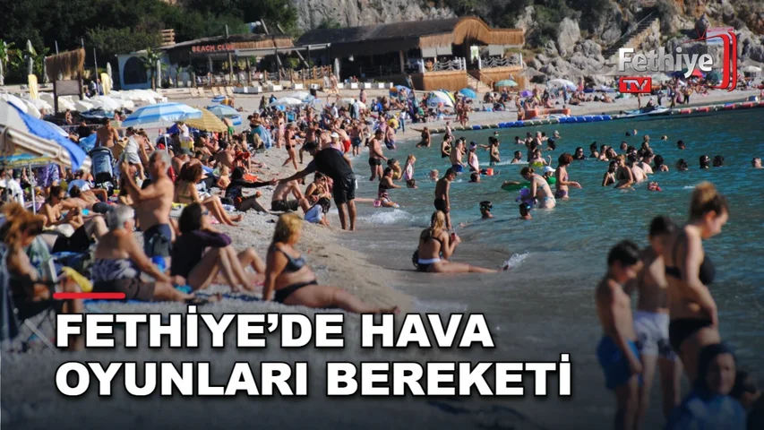 Ölüdeniz'de düzenlenen Uluslararası Hava Oyunları Festivali'nde turistler plajlarda ve paraşüt pilotlarını izliyor